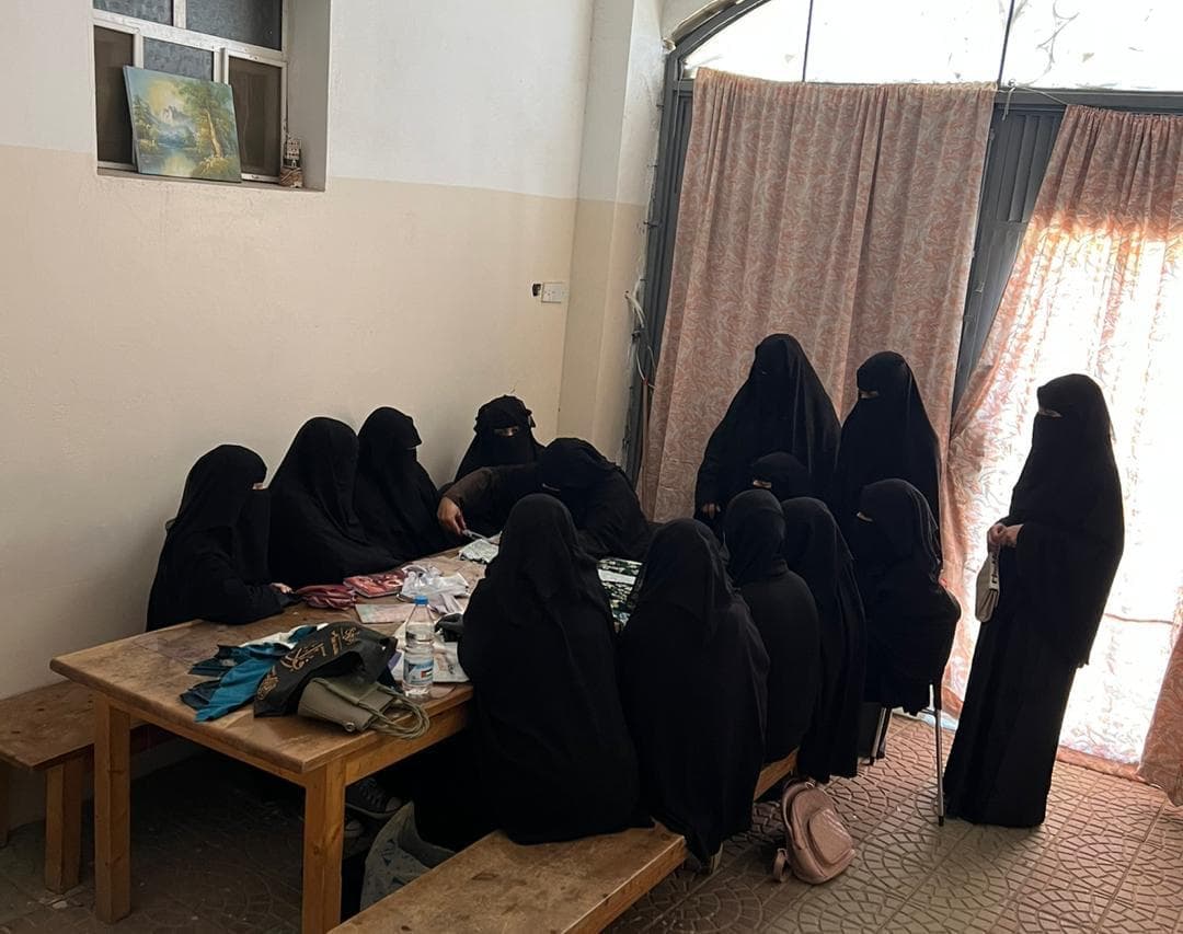 Women gathered around the long table in the classroom