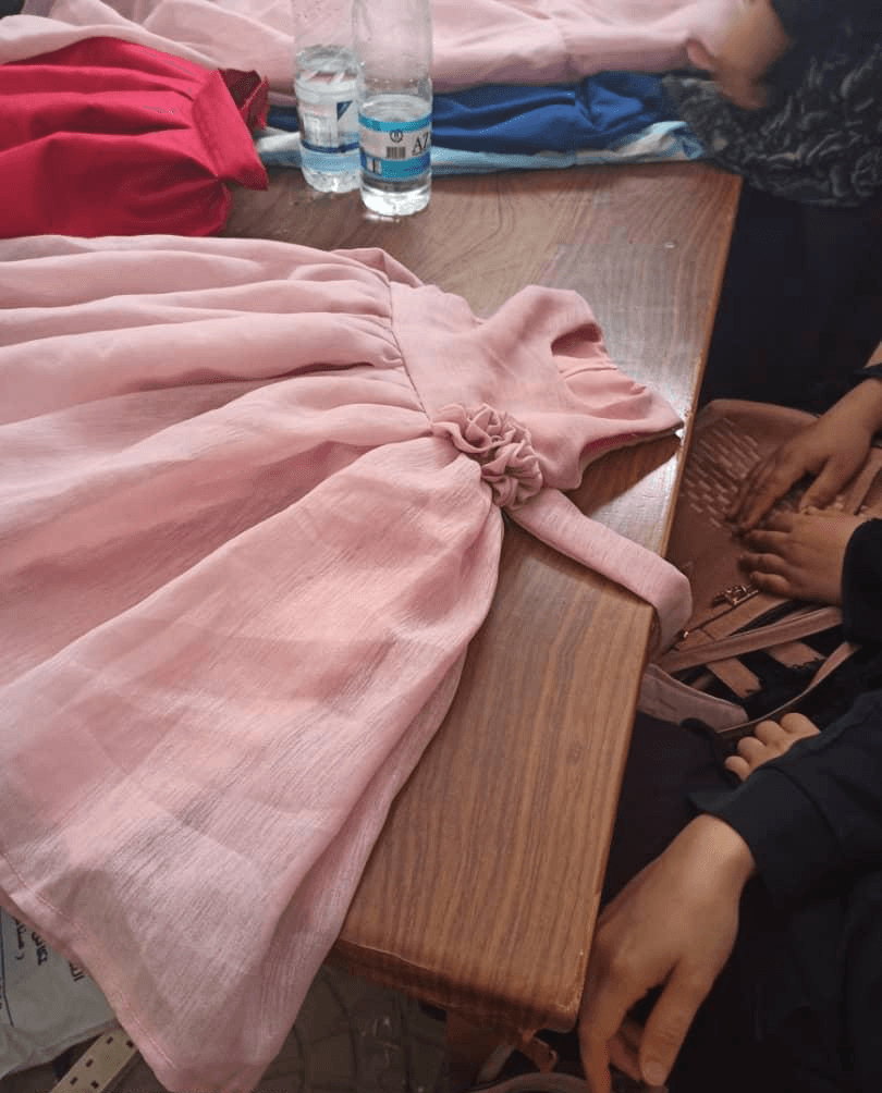 A rose-coloured child’s dress sewn in the classes