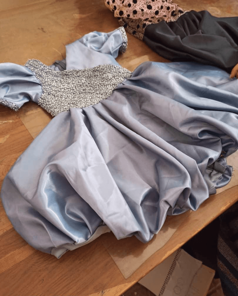 A silver-blue party dress laid out on the table
