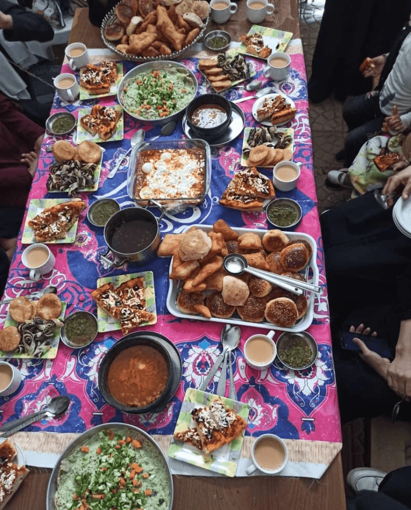 A shared meal spread on a colourful tablecloth